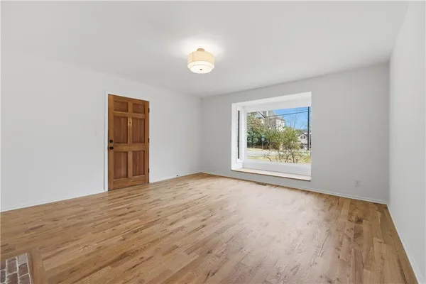 a view of empty room with wooden floor