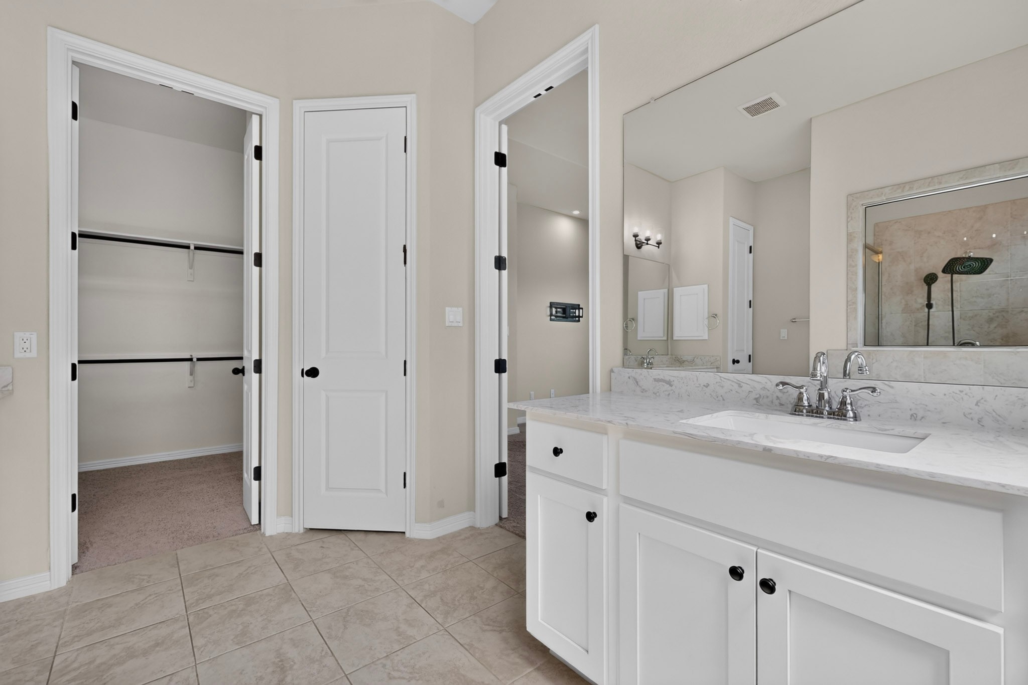 2433 La Mirada Street Leander, TX 78641 - Photo 8 of 25 A clean, functional bathroom featuring a marble-topped vanity and an adjacent walk-in closet.