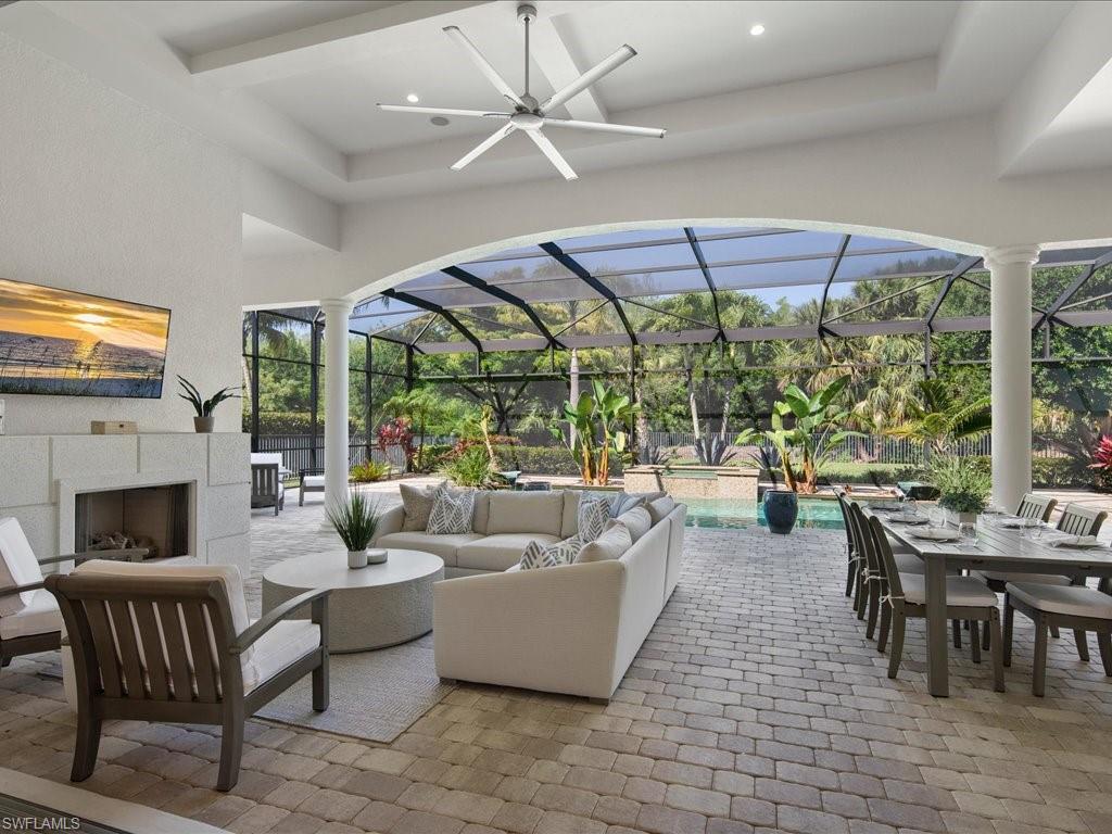 4249 Deephaven Lane Naples, FL 34119 - Photo 12 of 50 a living room with furniture a fireplace and a floor to ceiling window