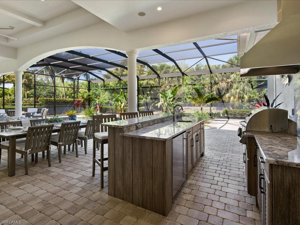 4249 Deephaven Lane Naples, FL 34119 - Photo 13 of 50 a kitchen with stainless steel appliances granite countertop a stove a sink and a dining table