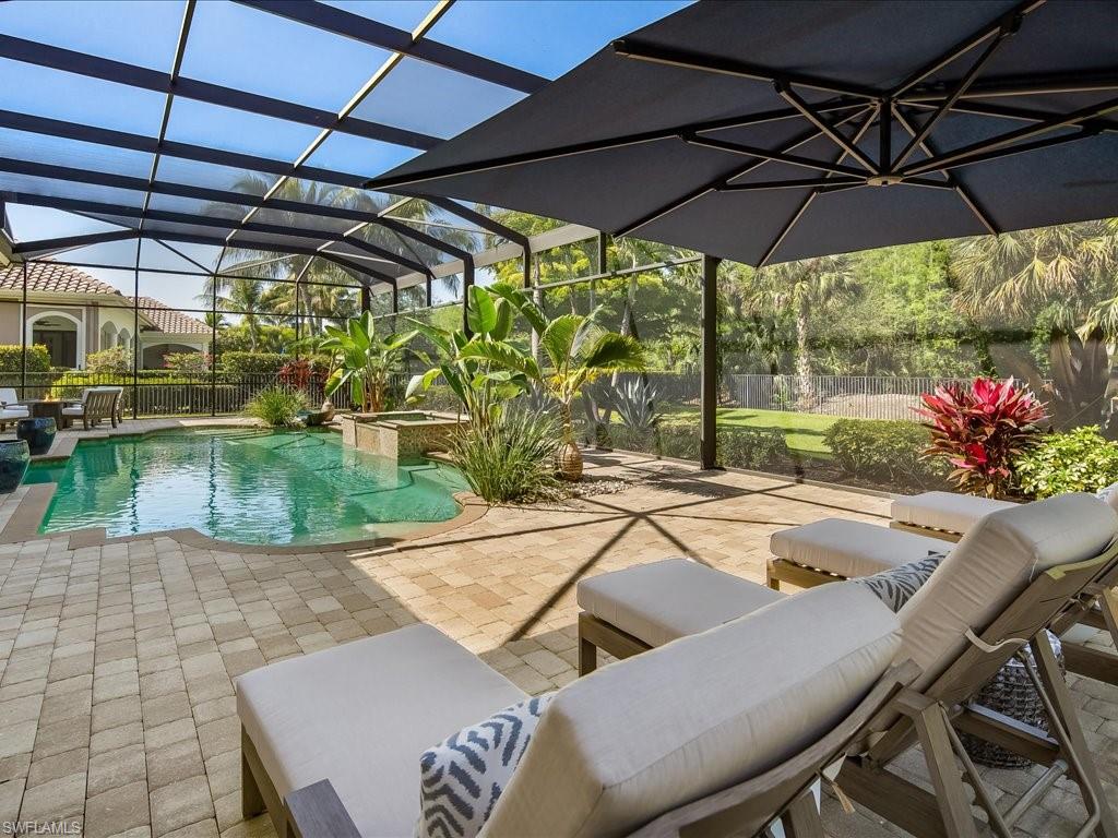 4249 Deephaven Lane Naples, FL 34119 - Photo 15 of 50 a view of a backyard with table and chair under an umbrella