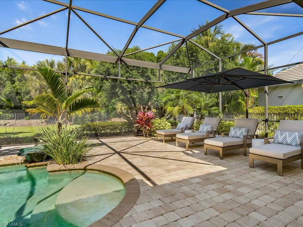 4249 Deephaven Lane Naples, FL 34119 - Photo 19 of 50 a view of pool with lawn chairs under an umbrella