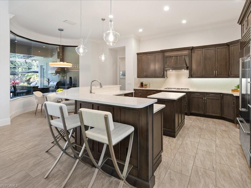 4249 Deephaven Lane Naples, FL 34119 - Photo 25 of 50 a kitchen with a dining table chairs sink and cabinets