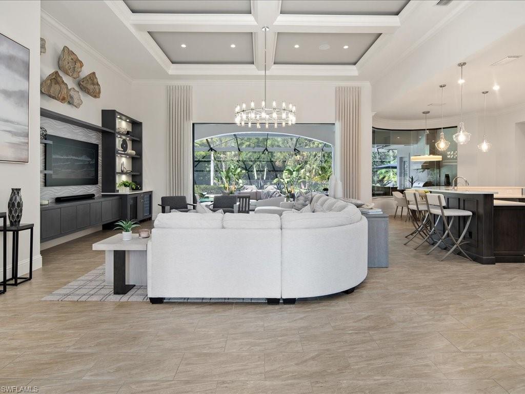4249 Deephaven Lane Naples, FL 34119 - Photo 3 of 50 a living room with couches a flat tv screen and kitchen view