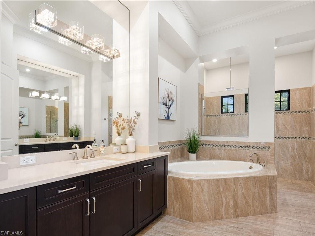 4249 Deephaven Lane Naples, FL 34119 - Photo 34 of 50 a bathroom with a bathtub a double vanity sink and mirror
