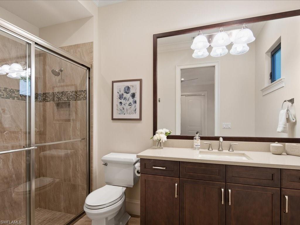 4249 Deephaven Lane Naples, FL 34119 - Photo 43 of 50 a bathroom with a sink a toilet a large mirror and shower
