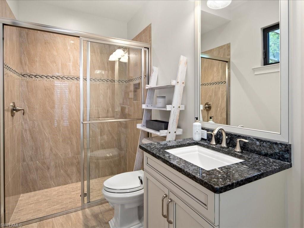 4249 Deephaven Lane Naples, FL 34119 - Photo 44 of 50 a bathroom with a granite countertop sink toilet and shower