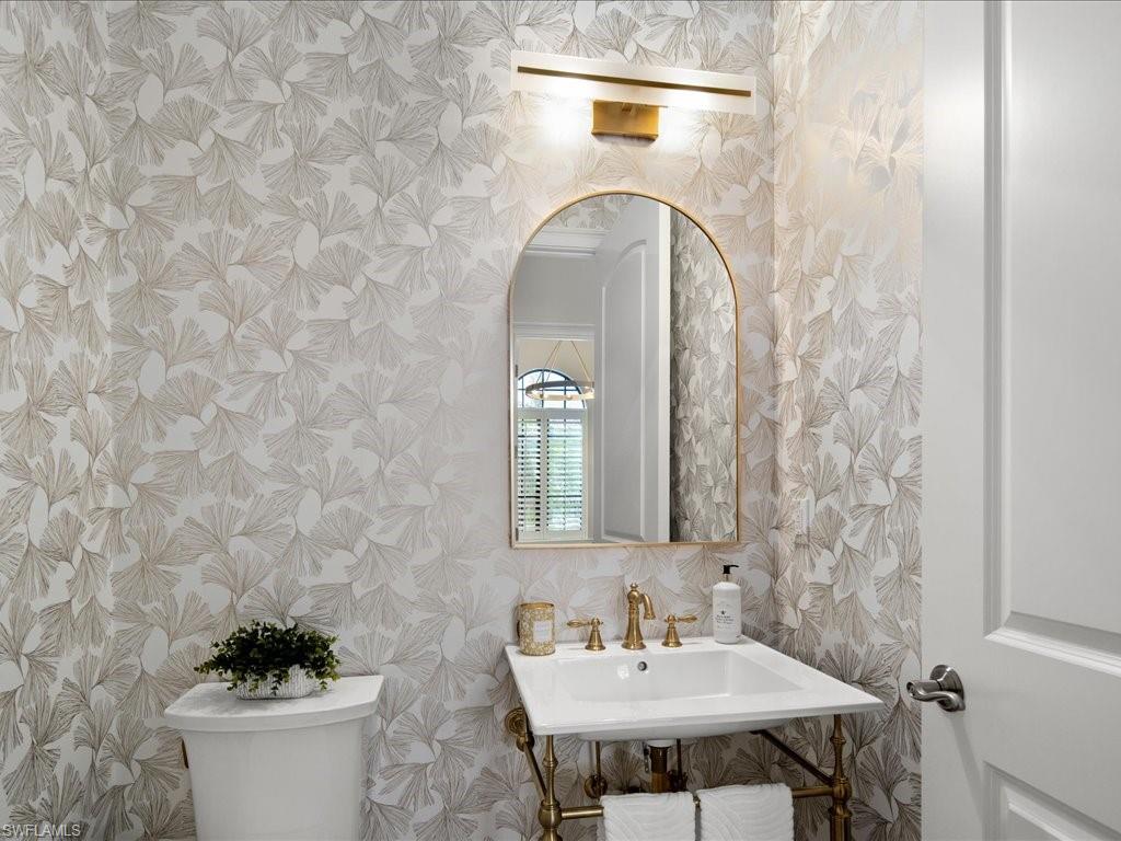 4249 Deephaven Lane Naples, FL 34119 - Photo 45 of 50 a bathroom with a sink a mirror and a toilet