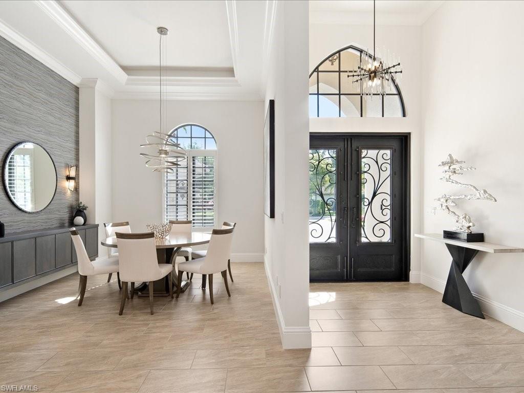 4249 Deephaven Lane Naples, FL 34119 - Photo 7 of 50 a dining room with furniture a chandelier and wooden floor