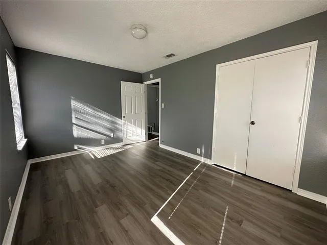 an empty room with wooden floor and staircase
