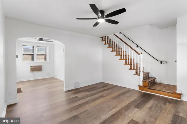 a view of a hallway with wooden floor and white walls