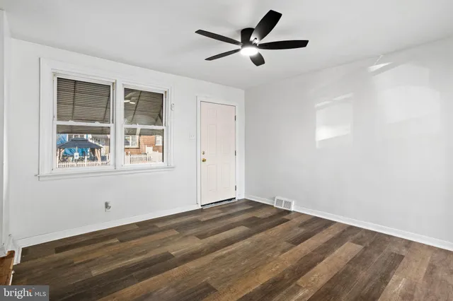 a view of a big room with wooden floor and windows
