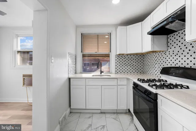 a kitchen with cabinets appliances a sink and a window