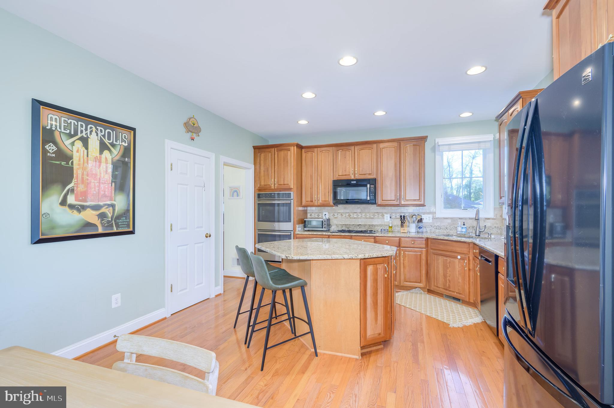 109 Amalfi Court Purcellville, VA 20132 - Photo 15 of 65 a kitchen with stainless steel appliances granite countertop a refrigerator a sink a stove a dining table and chairs