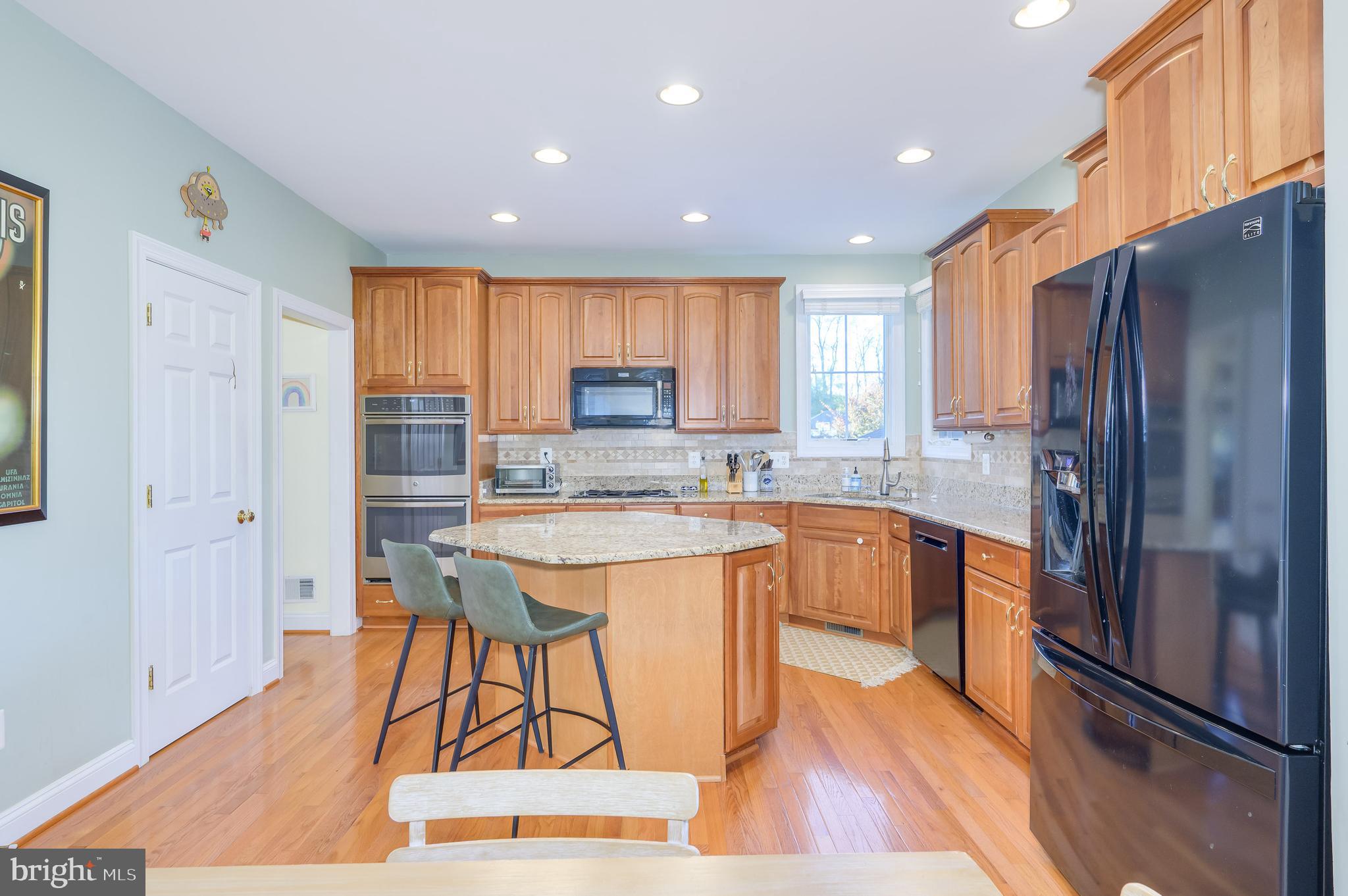 109 Amalfi Court Purcellville, VA 20132 - Photo 16 of 65 a open kitchen with stainless steel appliances granite countertop a refrigerator a sink dishwasher a stove and white countertops with wooden floor