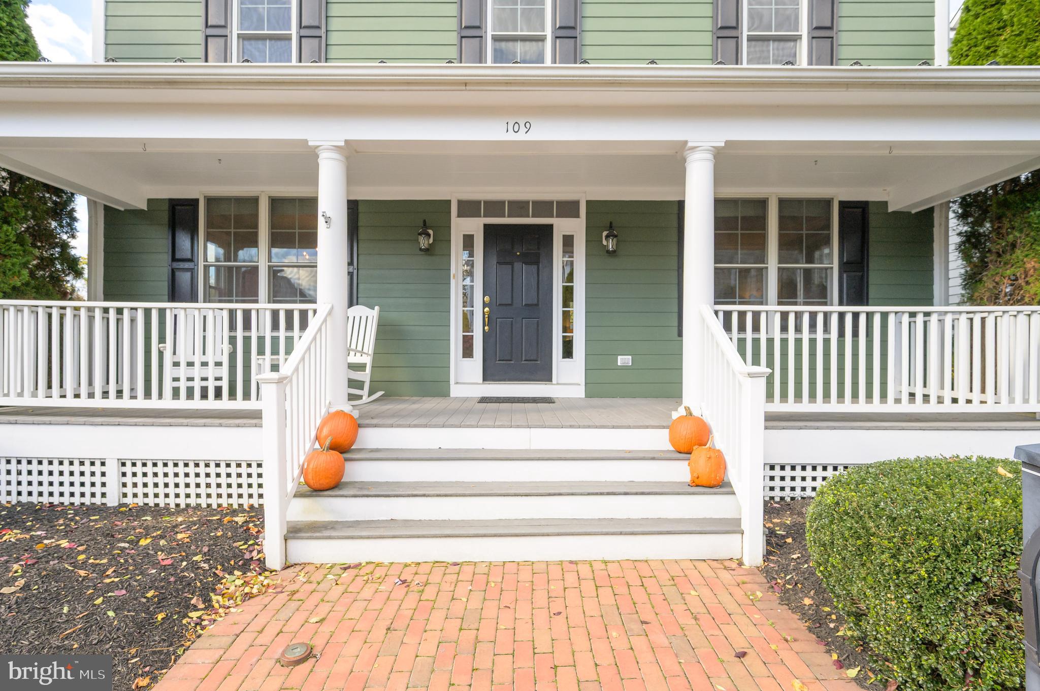 109 Amalfi Court Purcellville, VA 20132 - Photo 4 of 65 a view of a brick house with a chair and table next to a yard