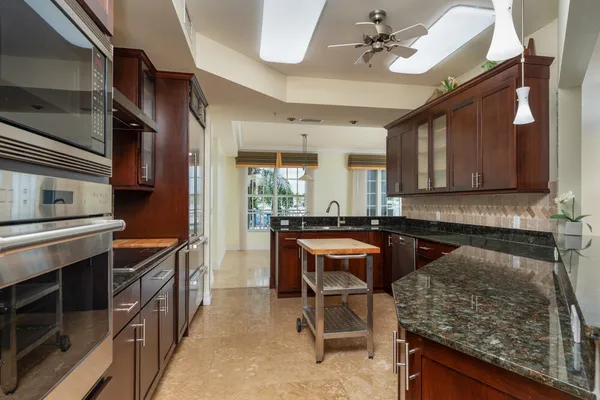 a kitchen with stainless steel appliances kitchen island granite countertop a stove and cabinets