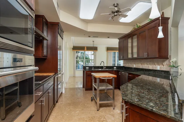 a kitchen with stainless steel appliances kitchen island granite countertop a stove and cabinets