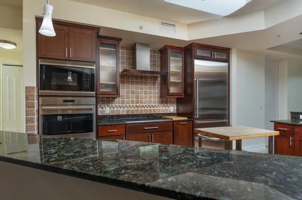 a kitchen with stainless steel appliances granite countertop a refrigerator and a stove