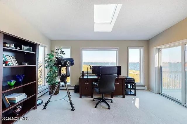 a view of a workspace with furniture and a window