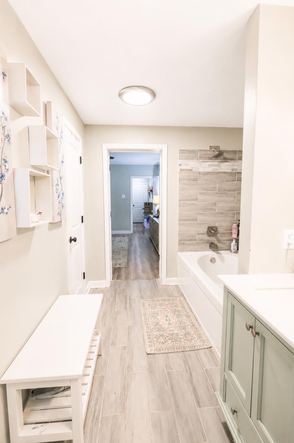 10093 Mt Carmel Road Brighton, TN 38011 - Photo 29 of 36 Contemporary bathroom featuring a built-in tub with tile surround, a single vanity with under-sink storage, and wood-finish flooring