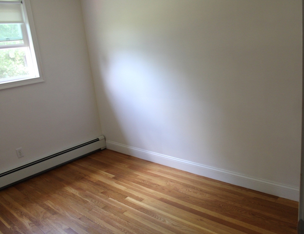 21 Whitcomb Drive Lancaster, MA 01523 - Photo 18 of 23 an empty room with wooden floor and windows