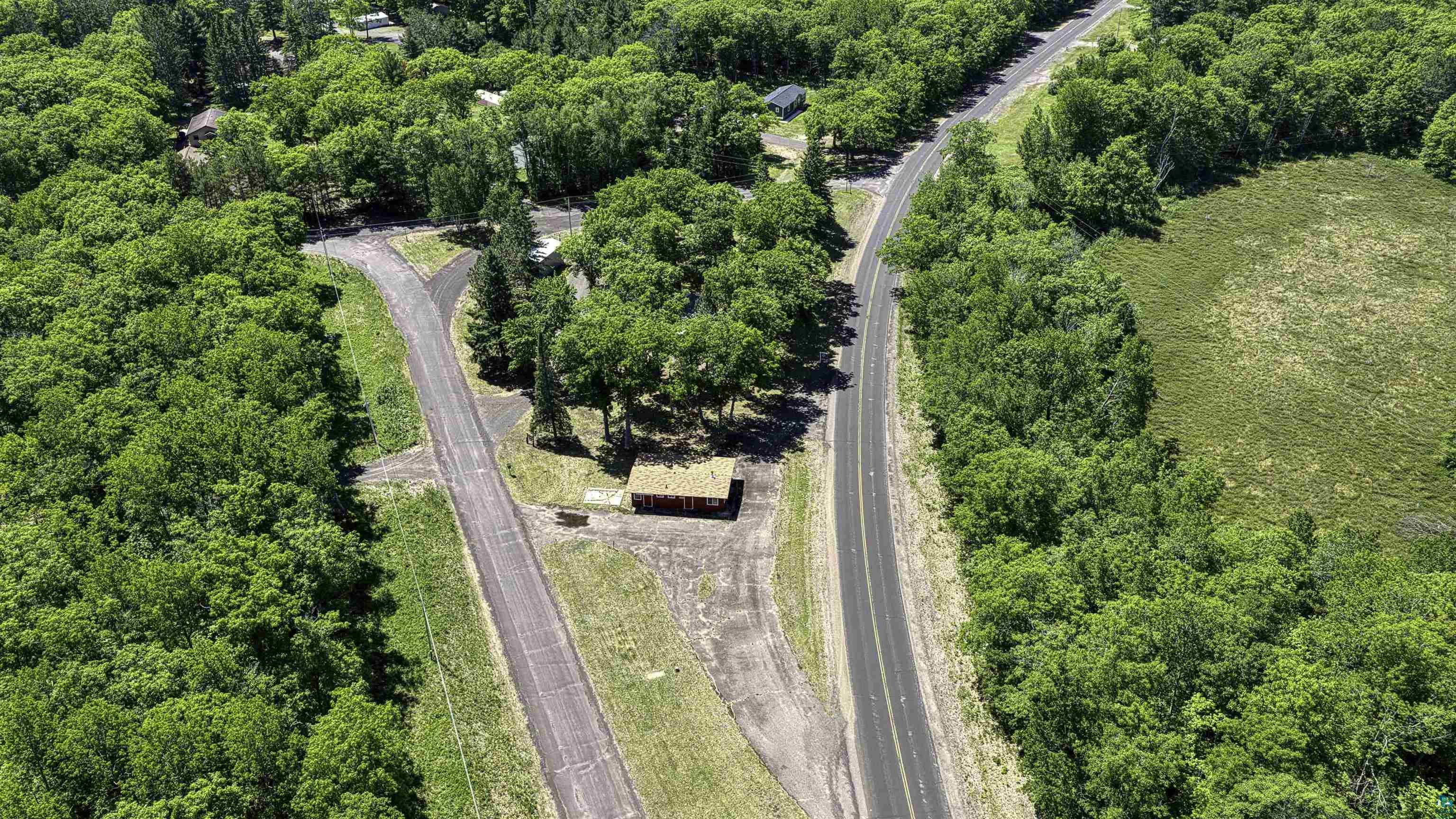 66075 Rooster Road Iron River, WI 54847 - Photo 9 of 52 Expansive parcel featuring a main roadway, a secondary paved drive, and a small, rustic structure