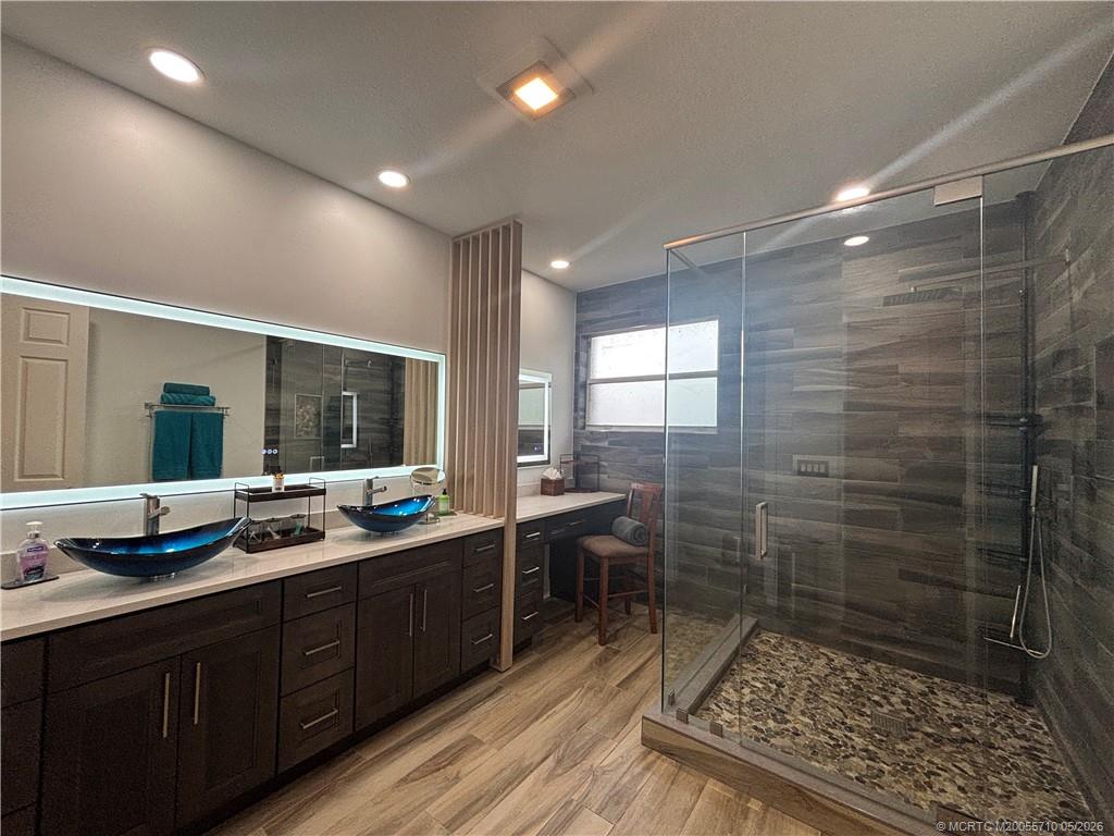 262 Southwest Walking Path, Unit 262 Stuart, FL 34997 - Photo 27 of 39 a bathroom with a double vanity sink a large mirror and a shower