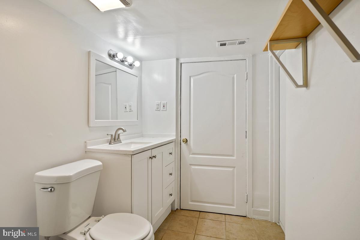471 Florida Avenue Northwest, Unit 1 Washington, DC 20001 - Photo 22 of 39 a bathroom with a toilet a sink a mirror and vanity