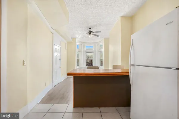 an empty room with wooden floor ceiling fan and windows