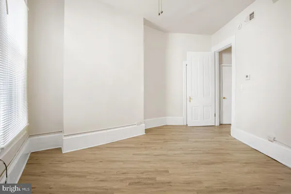 an empty room with wooden floor cabinet and closet