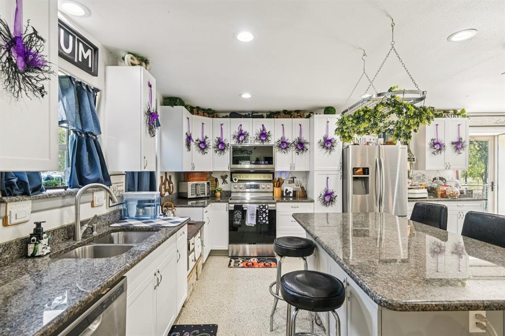 169 Chisam Road Valley View, TX 76272 - Photo 5 of 37 a kitchen with stainless steel appliances granite countertop a sink refrigerator and cabinets