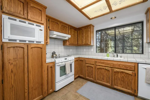 a kitchen with stainless steel appliances granite countertop a stove sink and cabinets