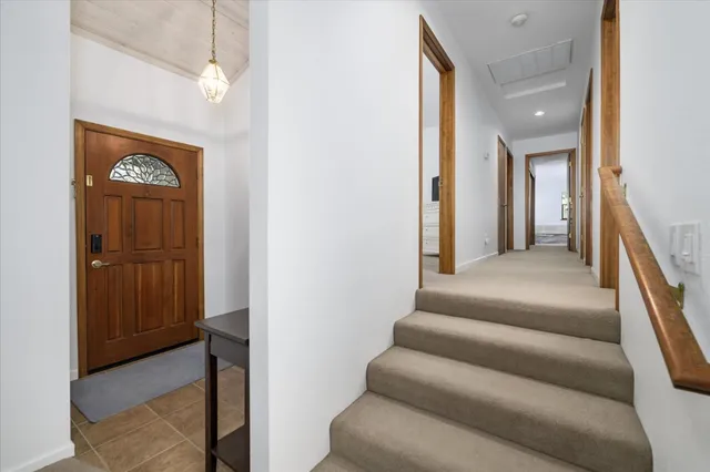 a view of a hallway with wooden floor and staircase