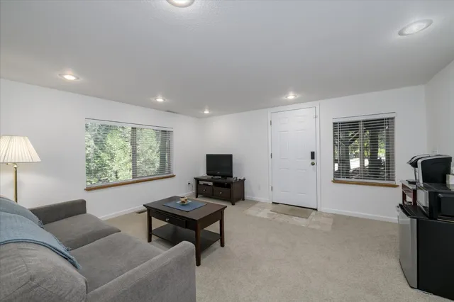 a living room with furniture a flat screen tv and a window