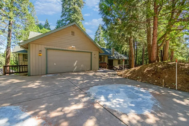 a view of a house with a yard and large tree