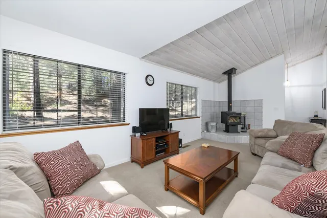 a living room with furniture a flat screen tv and a large window