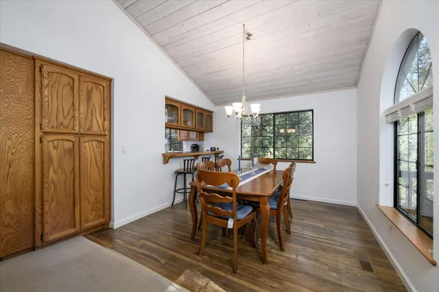 a dining room with furniture a chandelier and wooden floor