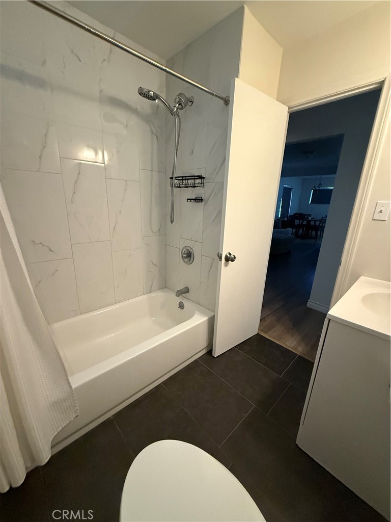 455 East Wilson Street Rialto, CA 92376 - Photo 2 of 8 Full bathroom with tub, shower head, sink, and toilet.
