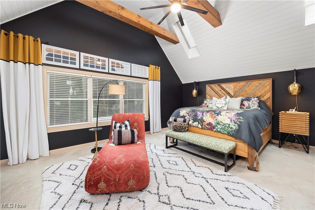 2097 Butler Road Wakeman, OH 44889 - Photo 21 of 34 Bedroom featuring light colored carpet, vaulted ceiling high, a skylight, ceiling fan, and beam ceiling