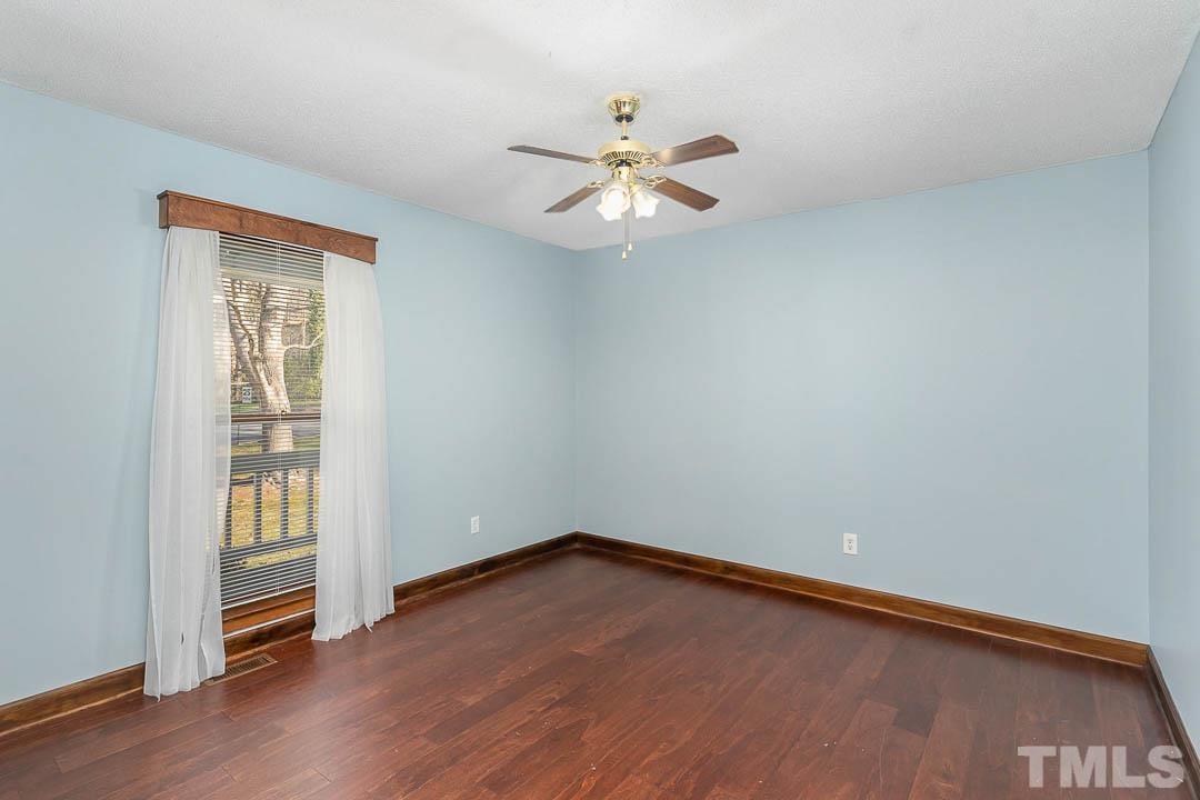 7244 Mine Shaft Road Raleigh, NC 27615 - Photo 12 of 23 an empty room with wooden floor fan and windows