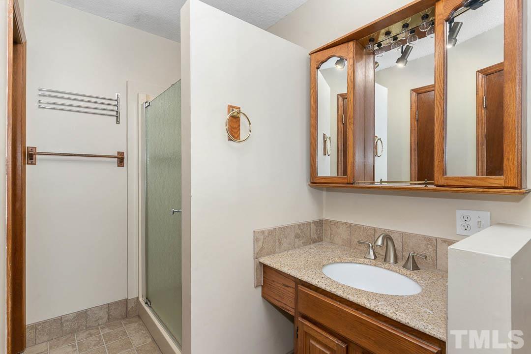 7244 Mine Shaft Road Raleigh, NC 27615 - Photo 10 of 23 a bathroom with a granite countertop sink and a mirror