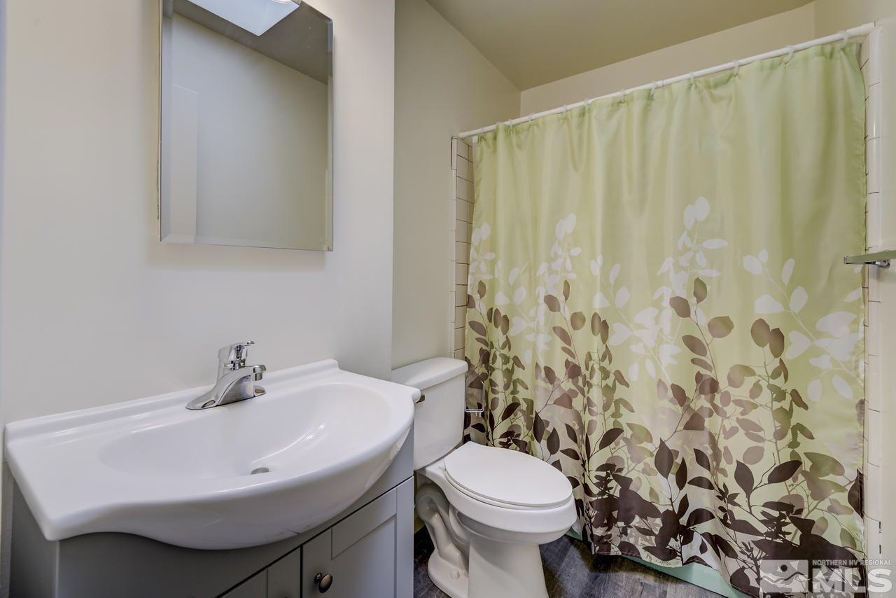 2001 Arcane Avenue Reno, NV 89503 - Photo 14 of 25 a bathroom with a sink a toilet and shower curtain