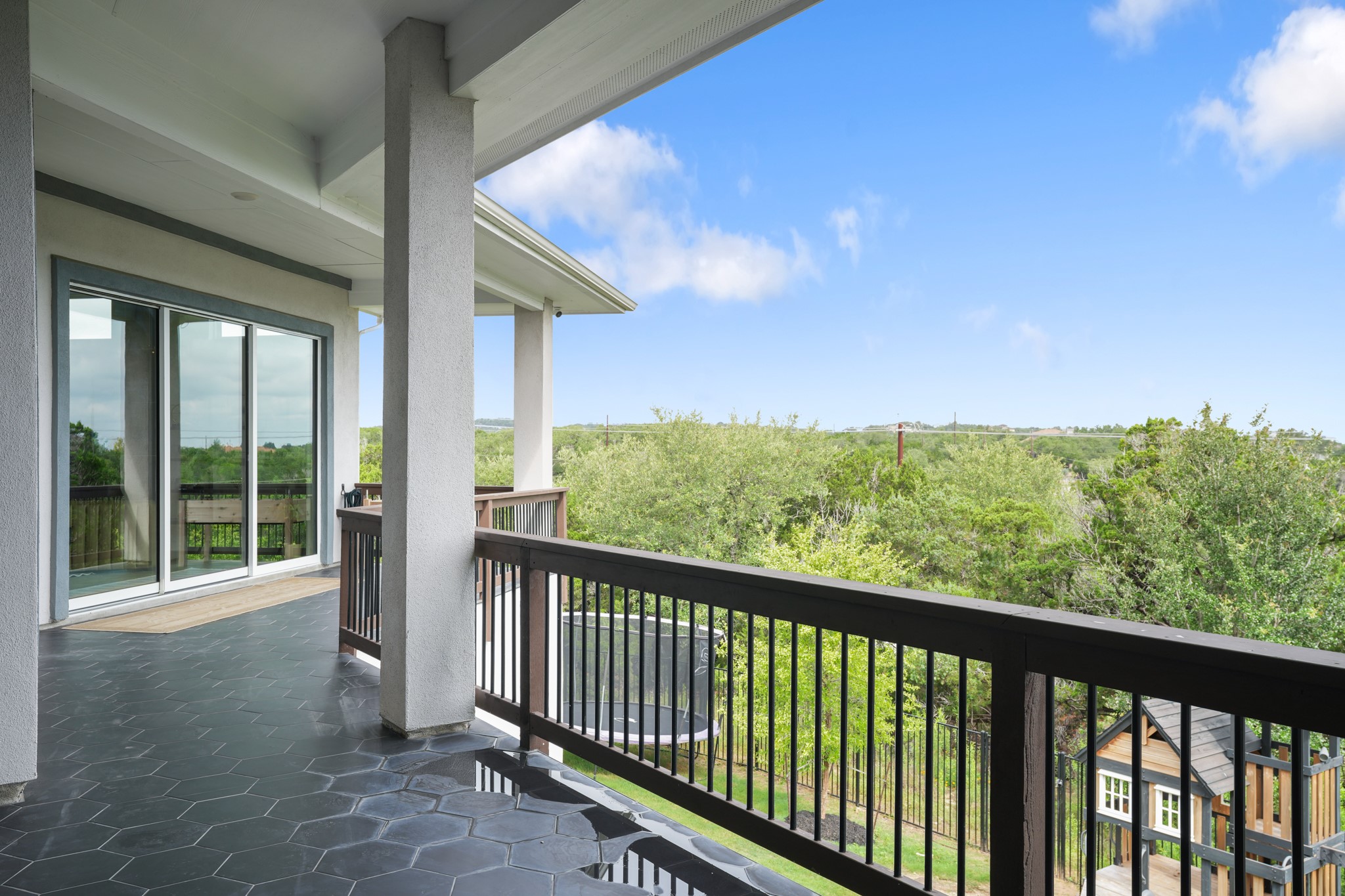 104 Lodestone Cove Austin, TX 78738 - Photo 23 of 40 An inviting tiled patio with a serene, elevated view of lush greenery.