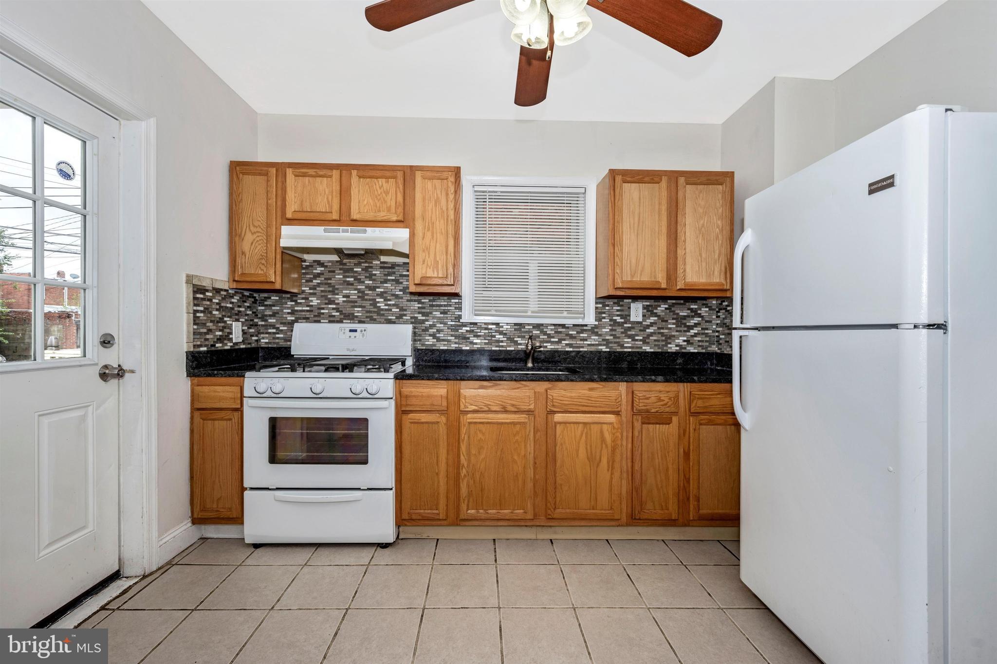 7041 Dunbar Road Dundalk, MD 21222 - Photo 13 of 28 Kitchen with granite and decorative tile backsplas