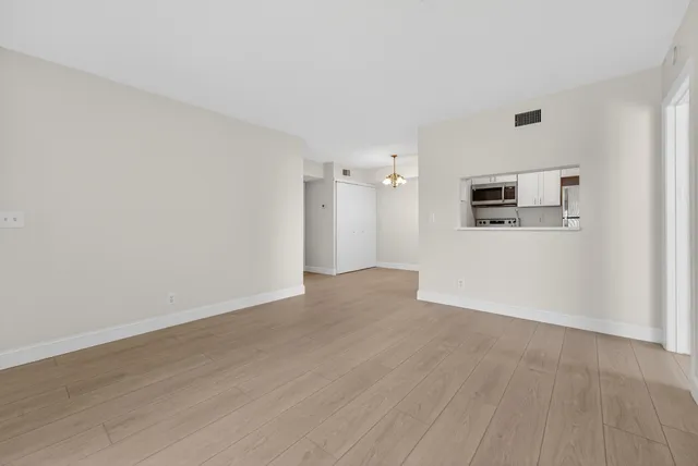 an empty room with wooden floor and white walls