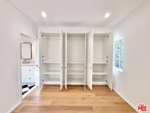 a view of walk in closet with empty racks