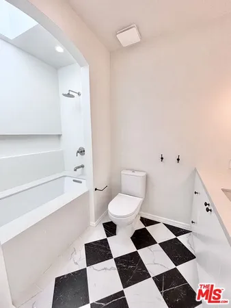 a bathroom with a black and white checkered floor