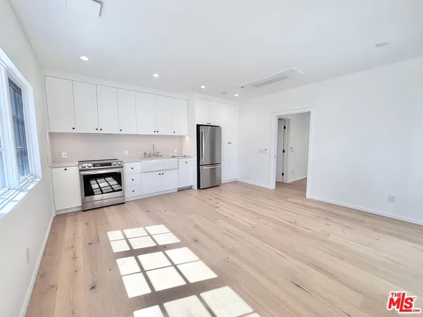 a kitchen with stainless steel appliances granite countertop a refrigerator and a stove top oven