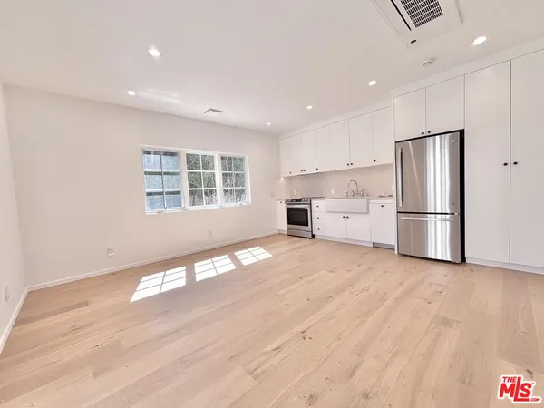 a view of a kitchen with a sink refrigerator and wooden floor
